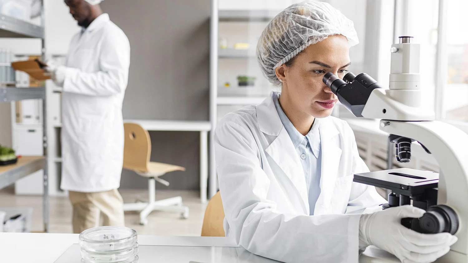 ricercatori in laboratorio di biotecnologie con microscopio a tavoletta